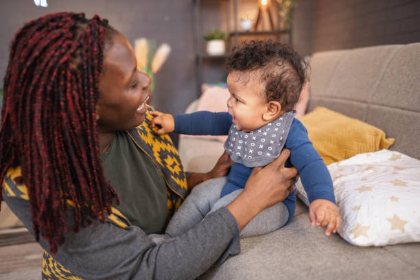 istock Mother holding and playing with her baby on the sofa 2194549070