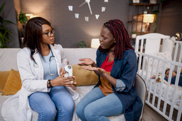istock Doctor explaining medical device to mother at home visit 2194549156