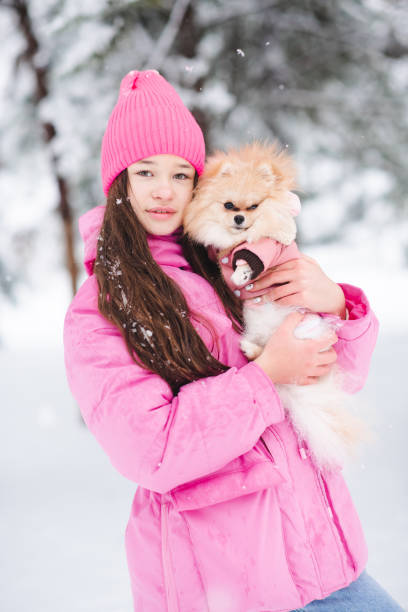istock Kid girl with dog over snow 2194549543