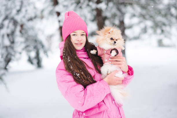 istock Kid girl with dog over snow 2194550433