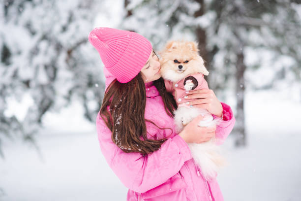 Kid girl with dog over snow