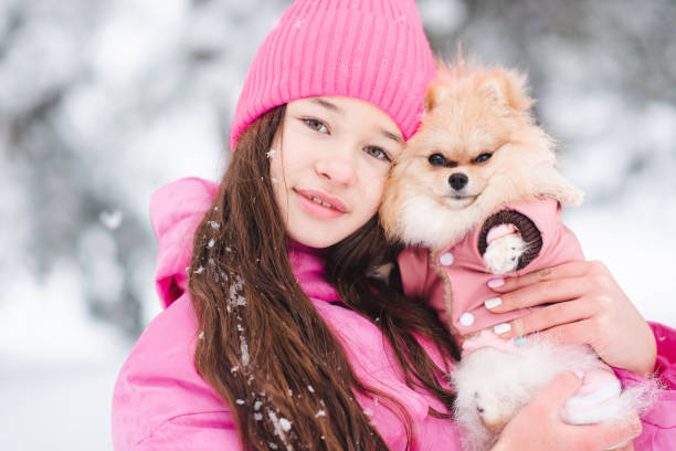 istock Kid girl with dog over snow 2194550581