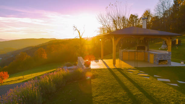 LENS FLARE: Backyard pavilion with outdoor kitchen at a golden autumn sunset