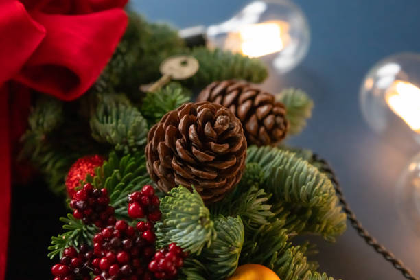 istock A beautifully arranged Christmas wreath features fragrant cinnamon sticks, pinecones, and colorful ornaments, illuminated by soft, warm lights. Danish spruce wreath. 2194557734