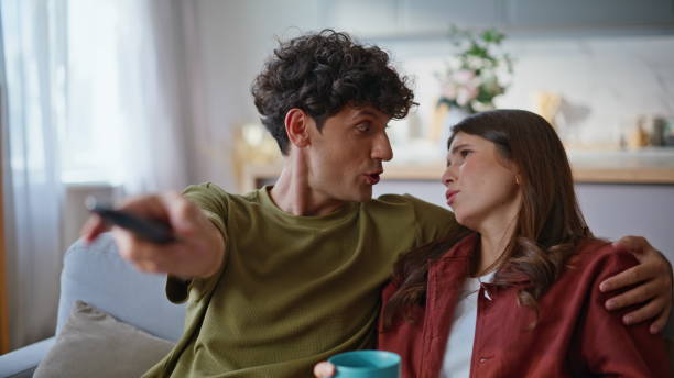 istock Young boyfriend switching channels remote controller closeup. Couple watching tv 2194558525