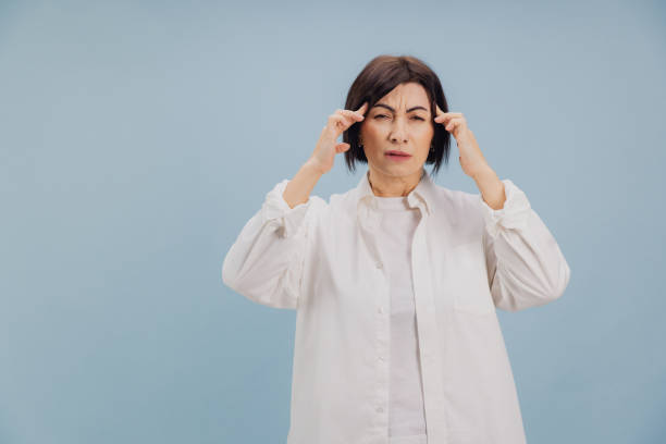 istock Mature Woman Suffering From Headache Touching Temples on Blue Background 2194561711