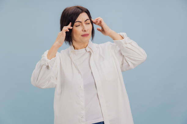 istock Brunette Woman Suffering Headache Touching Temples on Blue Background 2194561730