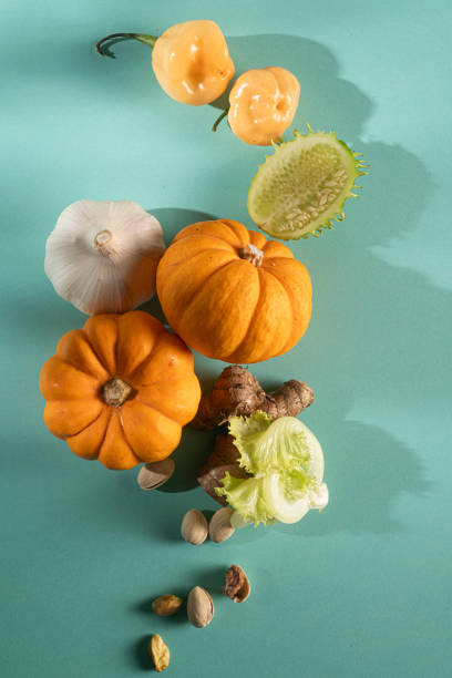 Miniature Pumpkin, Maxixe, Onion, Pistachio, Letture,and Ginger, the vegetables assortment on a blue background.