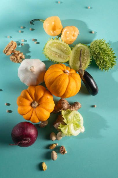 Miniature Pumpkin, Maxixe, Onion, Pistachio, Letture,and Ginger, the vegetables assortment on a blue background.