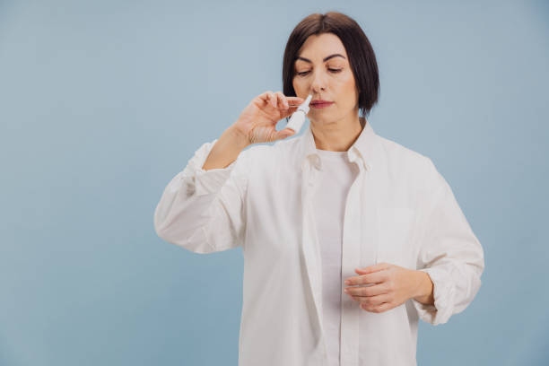 istock Middle aged woman using nasal spray for rhinitis treatment 2194562540