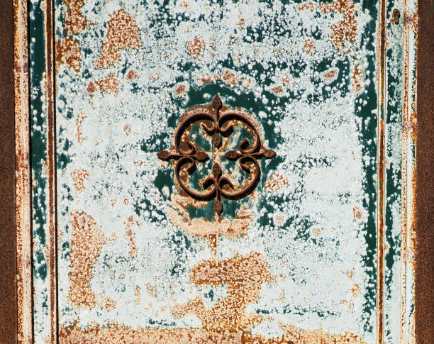 Vintage beautiful door to the courtyard, a gate with a beautiful turquoise-colored iron ornament covered with corrosion, giving it additional retro provance style.