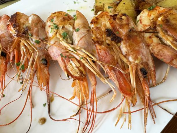 istock Grilled prawns with seasoned herbs on white plate 2194563579