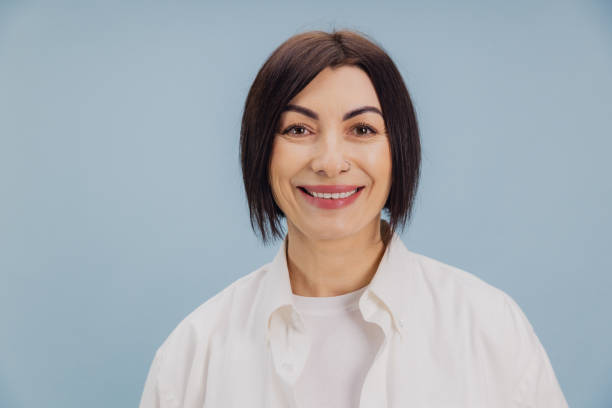 istock Smiling mature woman with nose piercing posing on light blue background 2194563604