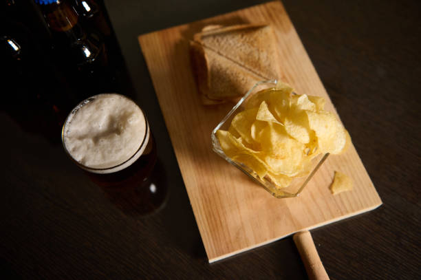 istock Snack Platter with Sandwiches, Chips, and Beer on a Wooden Surface 2194566398