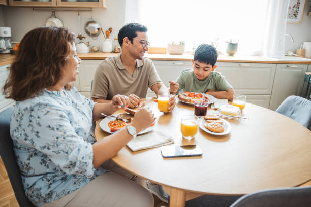 istock Family of three having breakfast together in the kitchen. 2194566983