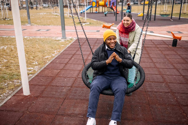 istock Young adults having fun in public park swinging each other 2194566991
