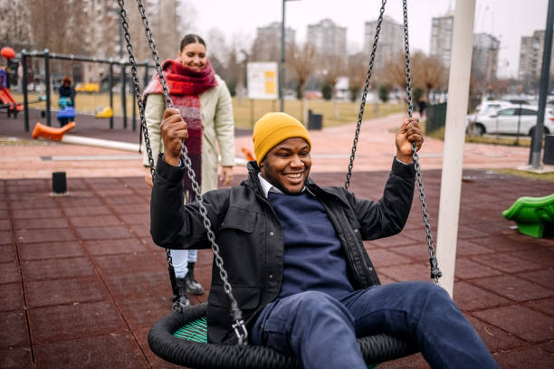 istock Young adults having fun in public park swinging each other 2194567000