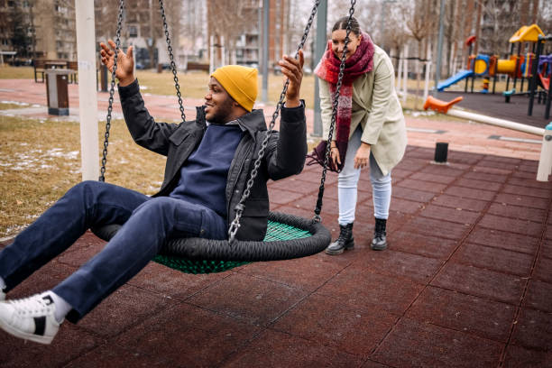istock Young adults having fun in public park swinging each other 2194567002