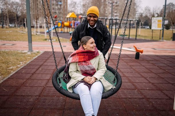 istock Young adults having fun in public park swinging each other 2194567003