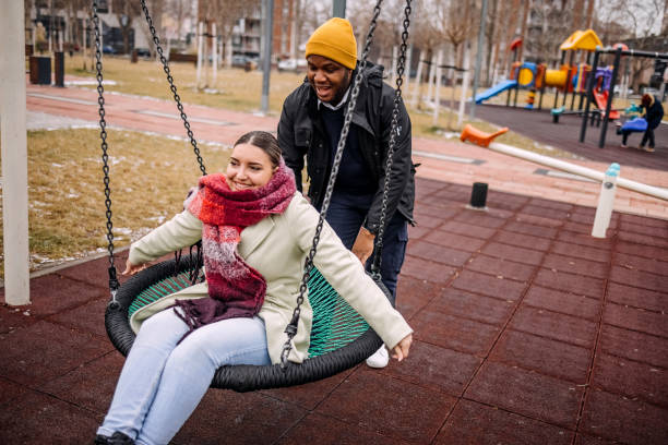 istock Young adults having fun in public park swinging each other 2194567007