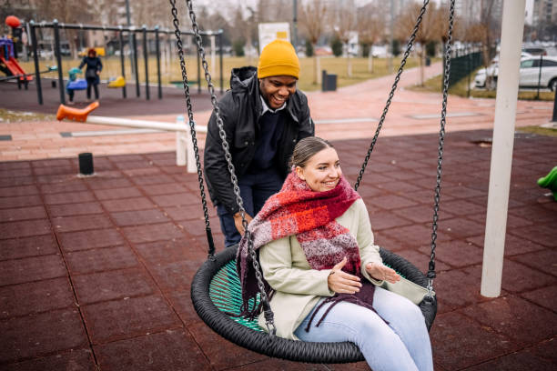 istock Young adults having fun in public park swinging each other 2194567015