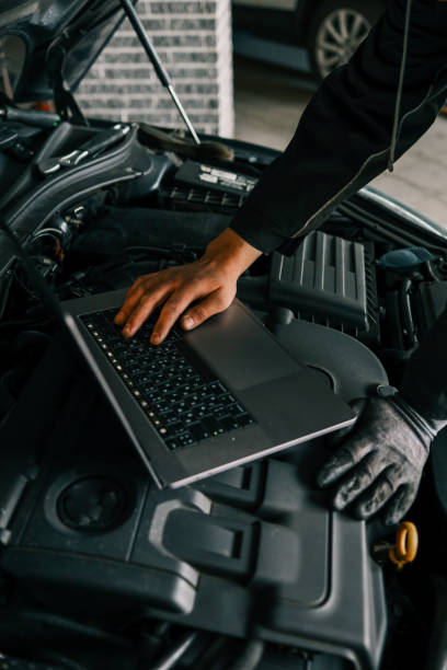 istock A mechanic using a laptop on a car engine for diagnostics in a garage. Highlights the use of technology in modern vehicle maintenance and repair 2194571809