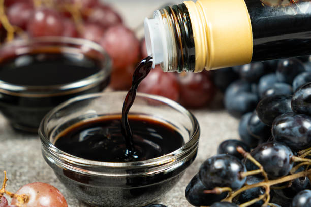 Balsamic vinegar pour from a glass bottle into a bowl