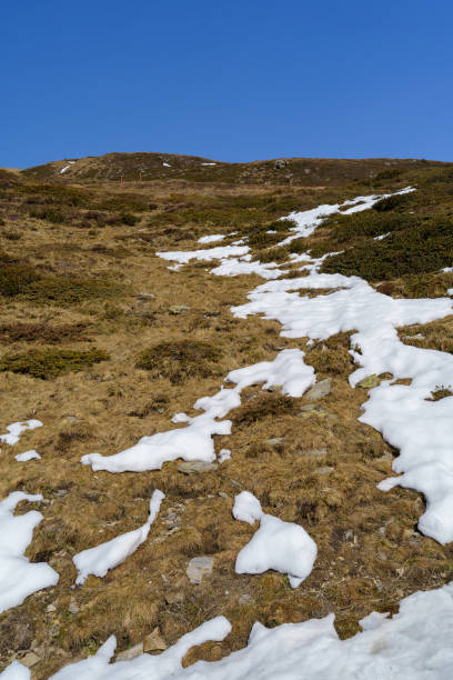 istock Mountainous Landscape with Melting Snow Patches Under Clear Blue Sky 2194576047