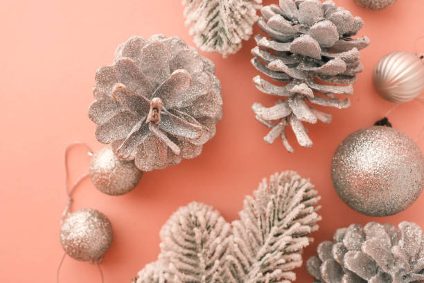 istock Festive Christmas composition featuring snow-covered branches, glittery pinecones, and shimmering ornaments on a pastel pink background. Perfect for holiday greeting cards 2194576736