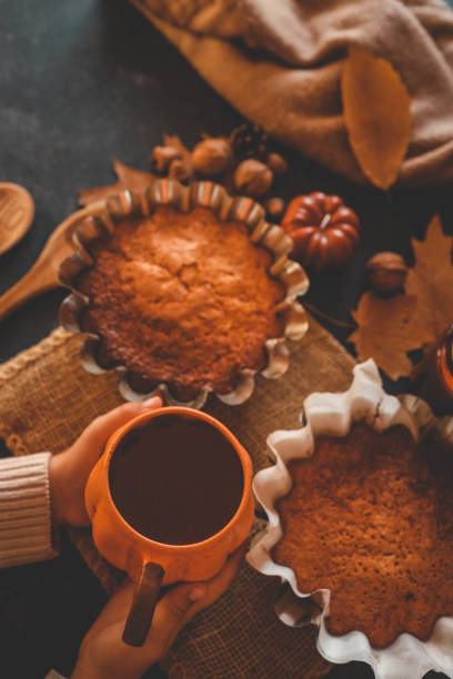 istock Cup of tea in hands and pumpkin pie, cozy autumn 2194577349