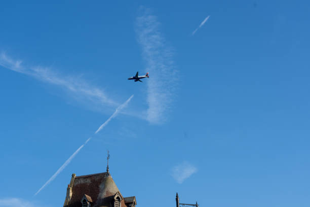 Windsor United Kingdom - August 11 2024; British Airways plane overhead flying through white cloud V shape a diagonal jetstream.