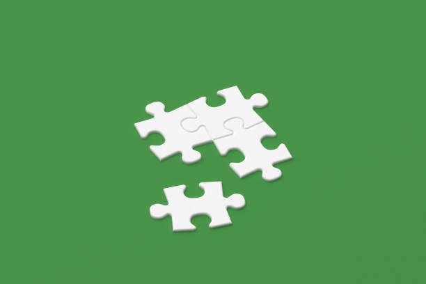 istock White puzzle pieces on a green background 2194578808