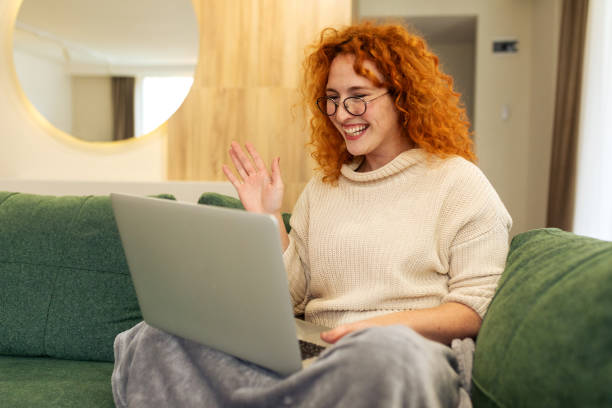istock Young woman sitting on the floor in her living room while using laptop computer and drinking coffee 2194578885