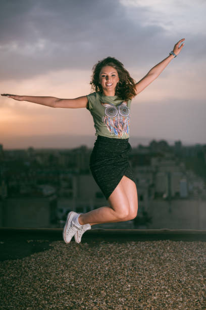 Happy young girl in Paris, jumping in Tuileries garden. Tourist spending her vacation in France