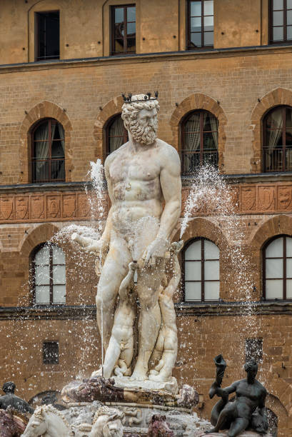 The majestic statue of Neptune, part of the Neptune Fountain, located in Piazza della Signoria, Florence, Italy. The intricate details of the marble sculpture and surrounding bronze figures highlight Renaissance artistry.