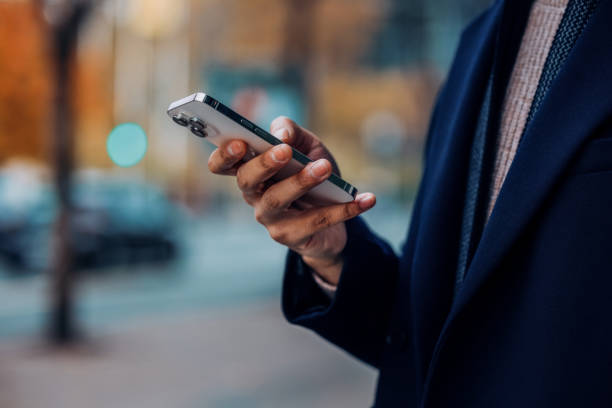 Close-Up of a Person Using a Smartphone Outdoors in Autumn