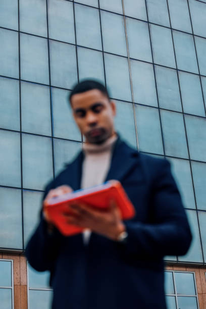 istock Businessman Holding a Folder in Front of a Modern Glass Building 2194591272