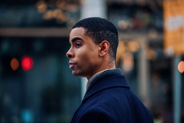 Young Man Facing Sideways in an Urban Outdoor Setting During Evening