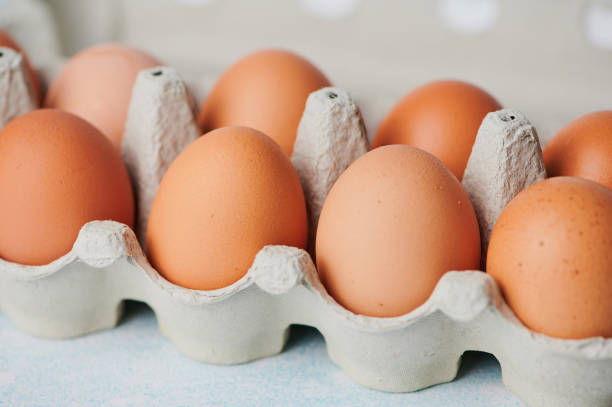 istock Brown eggs arranged in a carton on a light-colored surface 2194592318