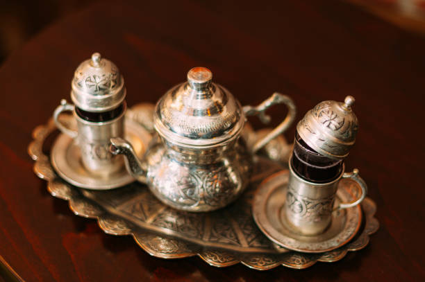 A collection of intricately designed golden and silver metal containers exhibited at the Souk Al Zel Market, showcasing traditional Arabian craftsmanship with an emphasis on elegance and cultural heritage.