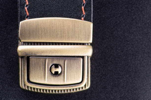 Brass lock on a black leather handbag. Close-up photo.