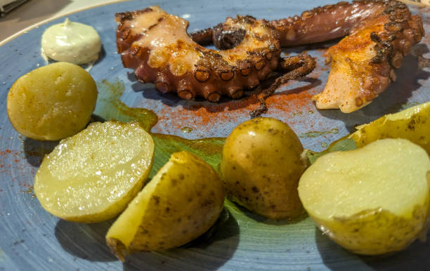 istock Grilled octopus served with roasted potatoes and sauce 2194594259