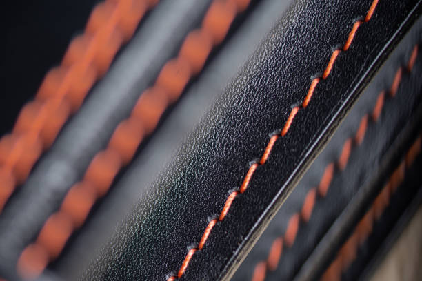 istock Black leather background. Texture, artificial leather with stitching. Diagonal fragment of stitches on leather. Close-up photo. 2194594715
