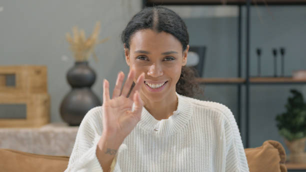 istock African Woman Waving Hand to Say Hello while at Home 2194598944