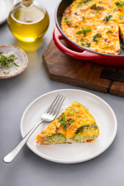istock Healthy frittata or quiche with broccoli and red pepper cooked in a cast iron pan, slice on a plate 2194599350