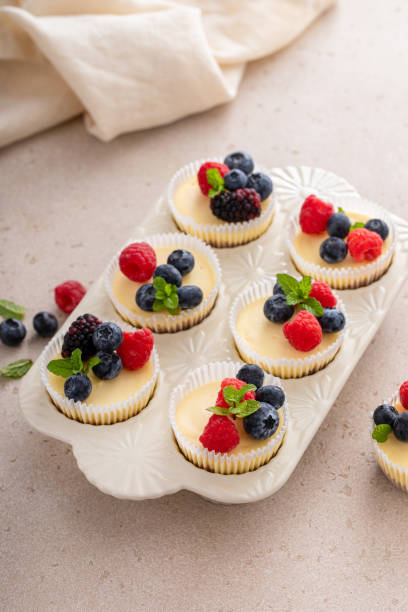 istock Mini vanilla cheesecakes cooked in a muffin pan served with fresh berries 2194599373