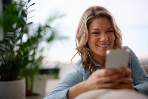 istock Happy woman texting on cell phone at home. 2194604453