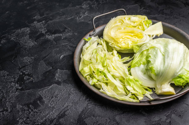 istock Fresh raw iceberg lettuce salad cut leaves. black background. top view 2194604536