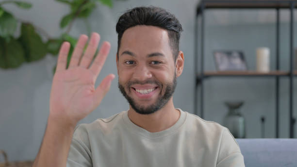 istock Hispanic Man Waving Hand for Video Chat at Home 2194604580