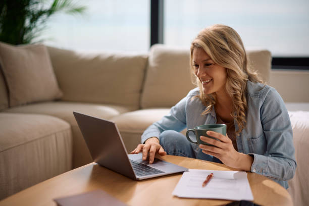 istock Happy woman having a cup of coffee while working at home. 2194605120